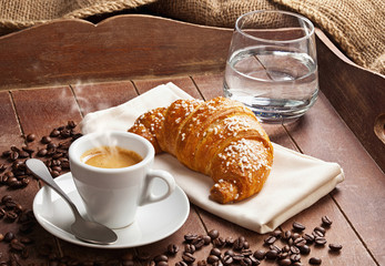 Espresso with croissant and glass of water.