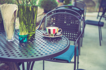 Coffee cup on table in cafe with vintage color tone