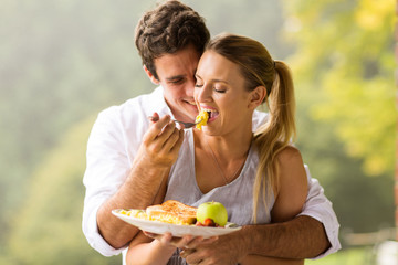 man feeding wife breakfast