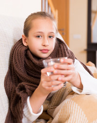 Girl in warm scarf drinking from glass