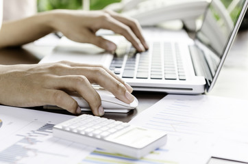 Woman using a mouse working on the computer