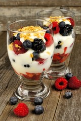 Healthy mixed berry, granola and yogurt parfaits on wood