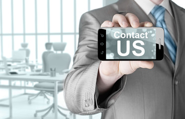 business man hand holding smartphone with the message contact us