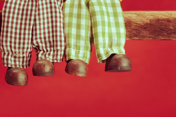 Legs of ceramic doll on red background