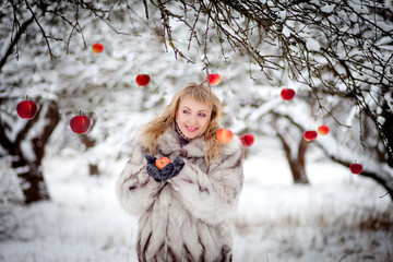 Girl in the winter garden with apples