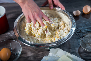 Cooking and home concept - close up of female hands kneading dou