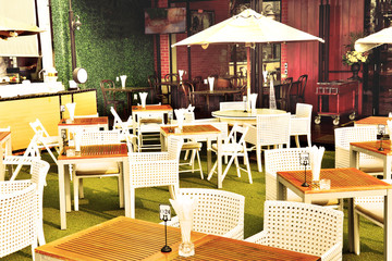 Empty outdoor restaurant tables in vintage filter
