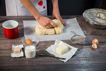Cooking and home concept - close up of female hands kneading dou