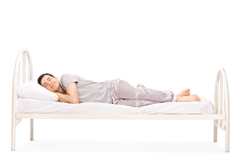 Happy young man sleeping in a bed - Powered by Adobe