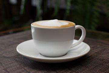 Cup of cappuccino over wooden table