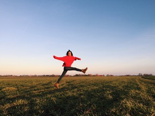 Frau springt über ein Feld
