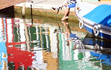 tourists with barefoot into the water on the Burano island