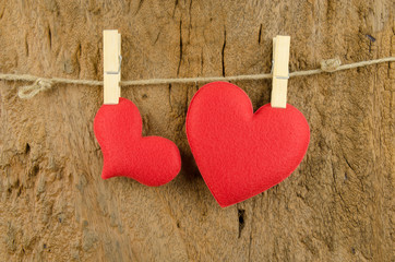 lovely red hearts hanging on the clothesline on old wood backgro