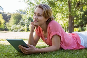 Pretty woman using tablet in park