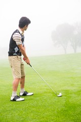Fototapeta premium Concentrating golfer lining up his shot