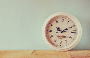 vintage white clock on wooden background