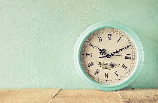 vintage mint clock on wooden background