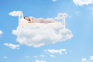 Man sleeping on a bed in the clouds