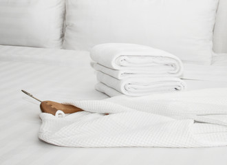 white bathrobe on the bed - obrazy, fototapety, plakaty