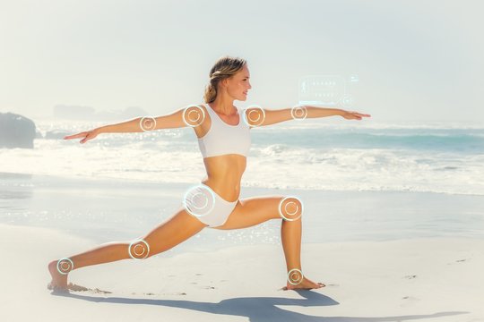 Composite image of gorgeous blonde in warrior pose by the sea