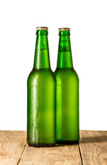 Two bottles of beer on old wooden table isolated