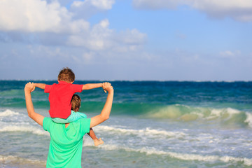 happy father and son playing on summer sea