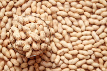 A lot of peanut in the shell in a glass. top view