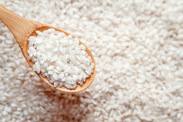 white rice in a wooden spoon. top view