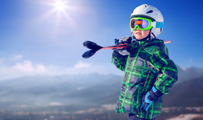 Boy in full ski equipment on the mountain view