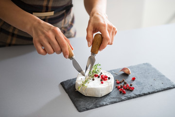 Closeup on young woman eating camembert
