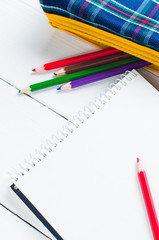 paper and colorful pencils on the table. View from above