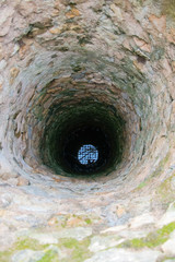 Very deep old water well with grid.