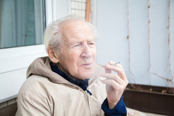 old man exhaling smoke
