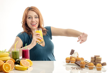 Woman choosing between fruits, smoothie,healthy food and sweets