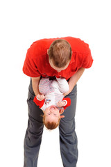 Father holding his son in hands, making baby yoga exersises