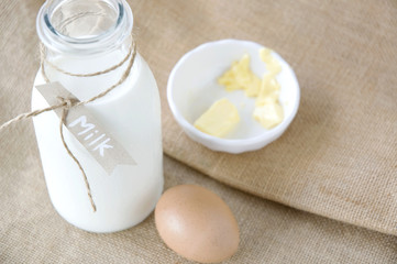 Obraz na płótnie Canvas milk with egg and butter on background