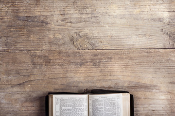 Bible on a wooden desk - obrazy, fototapety, plakaty