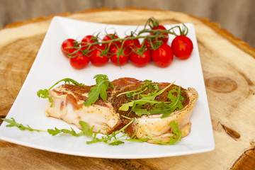 piece of crude meat , greens and tomatoes