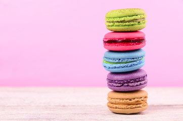 Fototapeta na wymiar colourful stack flavoured macaron on white wood background
