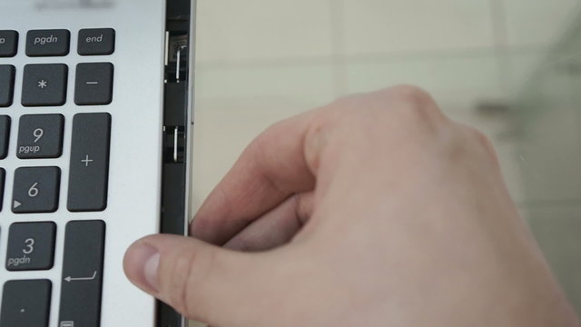 Man insert disk in laptop