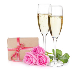 Two champagne glasses, gift box and pink rose flowers