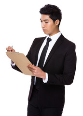 Businessman write on clipboard