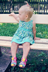 Little girl sitting on a bench in the Park