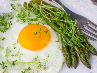 Breakfast of fried eggs, asparagus and watercress salad