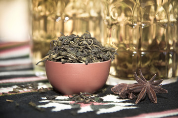 dry tea in front of cups with brewed tea - obrazy, fototapety, plakaty
