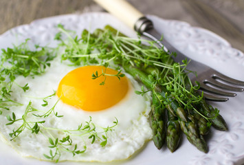 Breakfast of fried eggs, asparagus and watercress salad