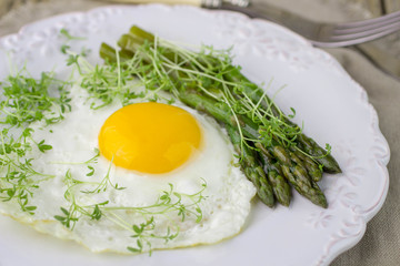 Breakfast of fried eggs, asparagus and watercress salad