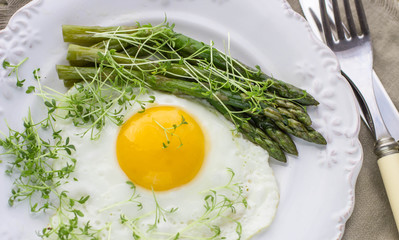 Breakfast of fried eggs, asparagus and watercress salad