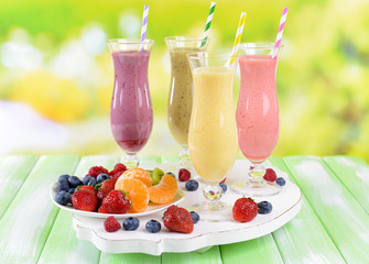 Delicious berry cocktails on table on bright background