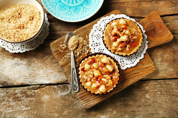 Mini cakes with nuts on wooden background